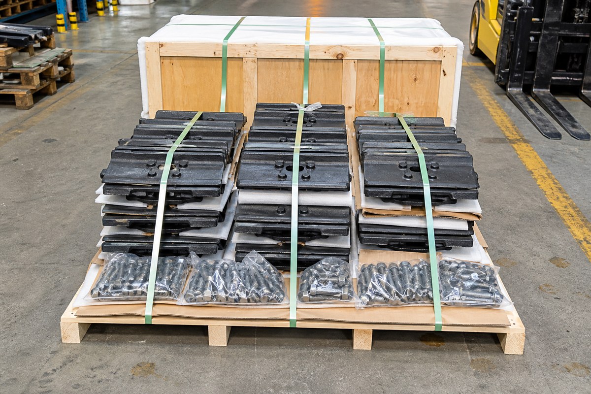 Excavator track shoes and undercarriage parts strapped on a pallet