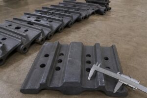 Excavator track shoes laid out for fitment inspection