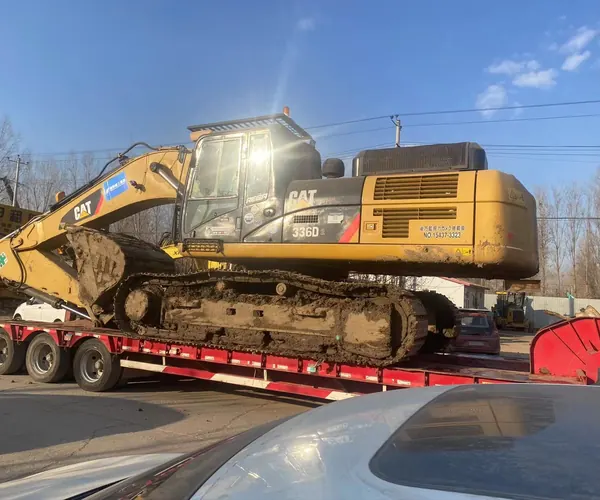 Used excavator loaded into shipping container at port