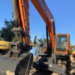 Front view of the refurbished Doosan DX210W wheeled excavator with boom and bucket